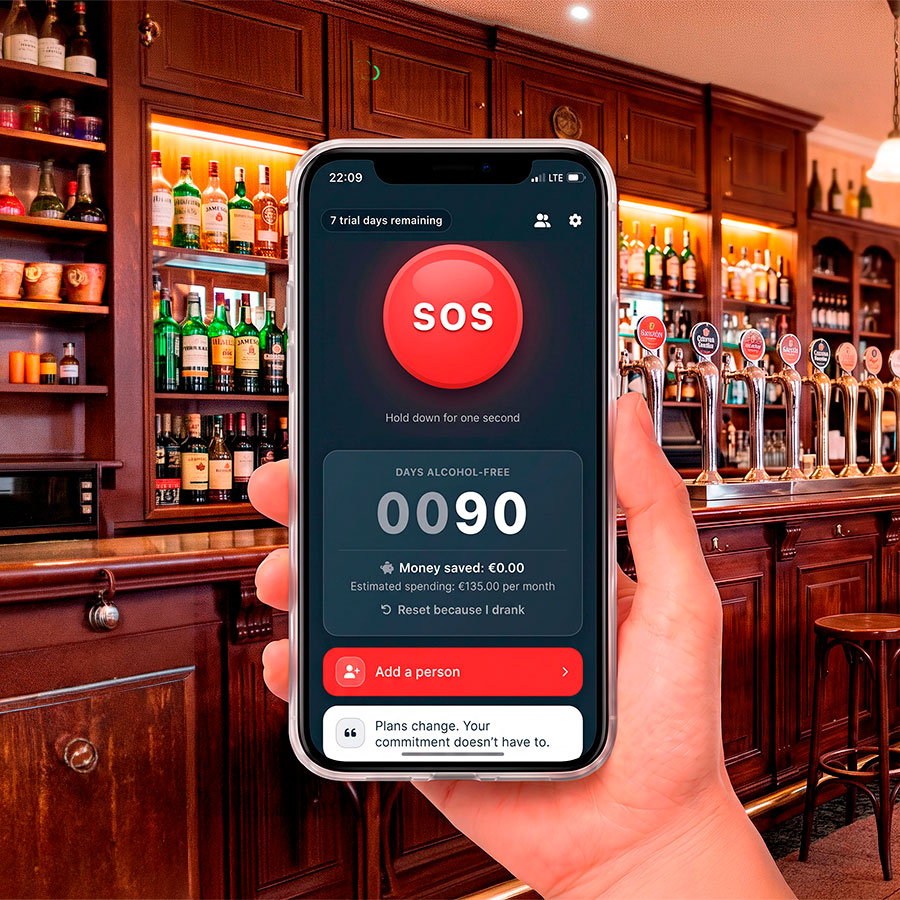 Une main tient un téléphone dans un bar, avec Sosober, le gros bouton SOS rouge et 90 jours sans alcool.